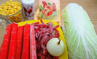 Salada com palitos de caranguejo e couve chinesa? Estamos preparando um pacote de comida. Retire as cascas da cebola e lave-a. Se usarmos pimentões frescos, lave-os, retire o interior e corte-os em tiras. Remova as folhas murchas do repolho. Retiramos os palitos de caranguejo pré-congelados e deixamos descongelar. Drene o líquido do milho.