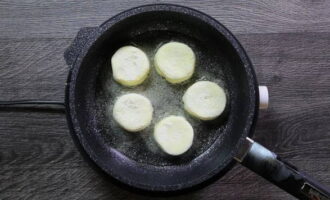 Heat vegetable oil in a frying pan and transfer the formed cheesecakes onto it.