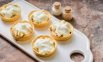 Susunod, magdagdag ng 2 tablespoons ng cream sauce sa bawat tartlet.Maaari kang gumawa ng higit pa kung pinapayagan ito ng kapasidad ng mga tartlet.