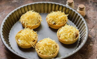 Polvilhe os pedaços com lascas de queijo e coloque de forma resistente ao calor. Leve ao forno pré-aquecido a 180 graus.