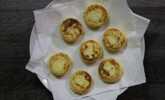 Remove excess oil by transferring hot cheesecakes to a stack of paper napkins.