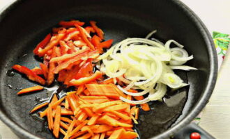 Cut the pepper in half, remove the white membranes and seeds from the halves. Cut the carrots and pepper halves into strips, cut the onion into half rings or feathers. Pour a little sunflower oil into a preheated frying pan and place the chopped vegetables. Start frying the vegetables, stirring with a spatula.