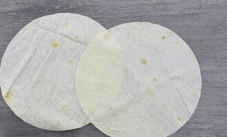 Take the pita bread and cut out 2 pieces that will fit freely in the pan.