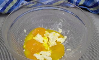 Berhati-hati memisahkan kuning telur daripada putih. Untuk melakukan ini, anda boleh membuat lubang pada telur, berhati-hati mengalirkan putih, dan kemudian keluarkan kuning dari cangkang. Letakkan kuning telur dalam mangkuk dengan mentega lembut.