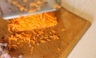 Grate half the carrots on a large-mesh grater. Cut half of the onion into cubes.