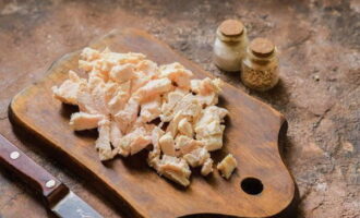 Alisin ang fillet ng manok mula sa sabaw, ilagay sa isang cutting board at palamig. Susunod, gupitin ito sa maliliit na cubes o i-disassemble ito sa mga hibla.