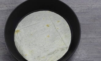 Kami mengeluarkan kuali dan meletakkan satu keping bulat roti pita.