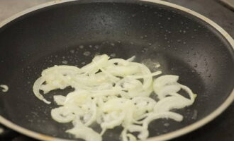 Saltee las mitades de cebolla en aceite vegetal caliente hasta que estén transparentes y suaves.