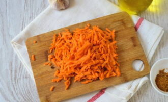 Three peeled carrots on a Korean carrot grater or a regular large one.