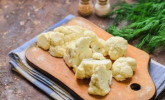 Esbandiu la coliflor sota l'aigua, assequeu-la i separeu-la amb cura en inflorescències.