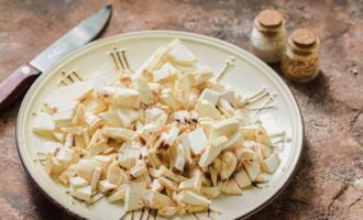 Frische Champignons waschen, die Schnittflächen an den Stielen erneuern, dann jeden Pilz in kleine Würfel schneiden.