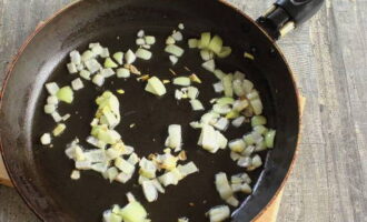 Die zweite Zwiebel schälen und fein in Würfel schneiden. Trocknen Sie die Pfanne über dem Feuer und gießen Sie Pflanzenöl hinein. Legen Sie die Zwiebel auf eine erhitzte Oberfläche und braten Sie sie an, bis sie transparent ist.