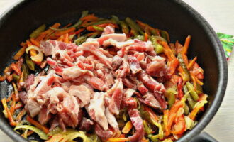 Wash the pork and cut it into oblong bars. When the vegetables become soft, place the meat in the pan and stir.