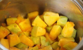 Aggiungete poi i cubetti di polpa di zucca alle verdure saltate. Friggere le verdure a fuoco medio per 5 minuti, mescolando con una spatola. Successivamente versare mezzo bicchiere d'acqua in modo che le verdure inizino ora a stufare. Per la zucca matura saranno sufficienti 15 minuti. Al posto dell'acqua potete aggiungere brodo vegetale o di carne.