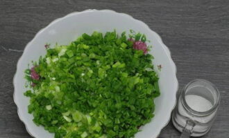 Lave e seque as cebolas verdes. Pique as verduras finamente com uma faca e acrescente aos ovos.