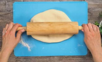 Place the filling in the middle of all dough circles. We wrap it in dough, form a flat cake, turn it seam side down and carefully roll it out.