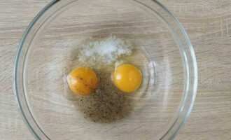 A continuación, tome un recipiente hondo y cómodo y rompa en él dos huevos de gallina. Agrega sal y una o dos pizcas de pimienta negra molida a tu gusto. Mezclar todo bien con un batidor.