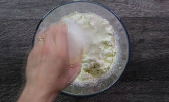 Sift the required amount of flour into the cottage cheese through a sieve, add sugar and salt.