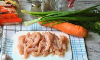 Kami memotong fillet ayam yang dibasuh dengan baik ke dalam jalur.