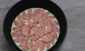 Corte a salsicha em semicírculos ou tiras e distribua sobre o pão sírio.