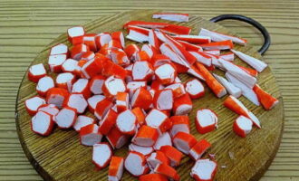 Having freed the crab sticks from the shell, cut three into triangles, cut the remaining ones into circles.