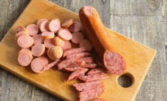 Ihanda ang lahat ng mga sausage. Siguraduhing alisan ng balat ang lahat mula sa pambalot.Gupitin ang sausage sa mga cube o strips, ayon sa gusto mo. Gupitin ang mga sausage sa mga hiwa.