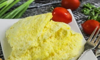 Divida a omelete fofa preparada em porções e coloque em pratos. Sirva imediatamente antes que o prato esfrie.