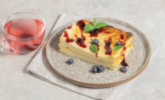 Cottage cheese casserole in the oven, just like in kindergarten, ready! Cool the hot product. Cut and serve in portions, adding syrup, jam or condensed milk. Decorate with mint leaves and fresh berries if desired. We serve additional drinks. Bon appetit!