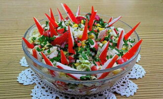 Salada com palitos de caranguejo e couve chinesa está pronta! Sirva o aperitivo e decore com palitos de caranguejo cortados em triângulos. Sirva à mesa. Bom apetite!